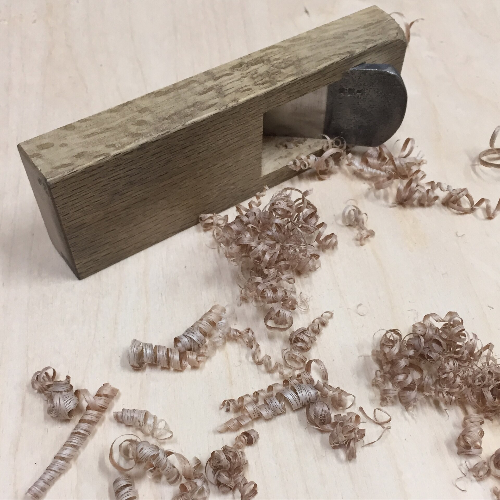 Japanese kanna handplane with a curl of wood shavings